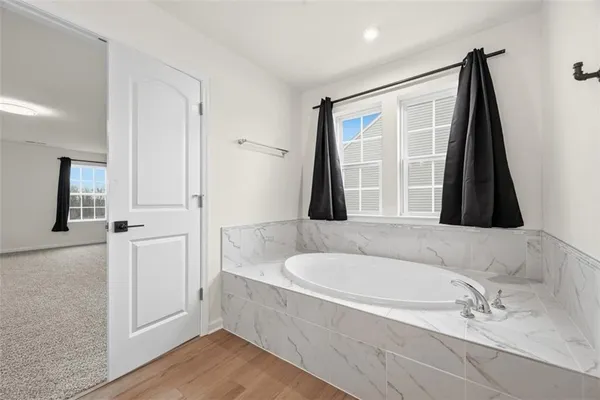 a bathroom with a tub sink and mirror