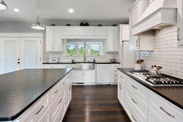 a kitchen with stainless steel appliances granite countertop a sink stove and cabinets