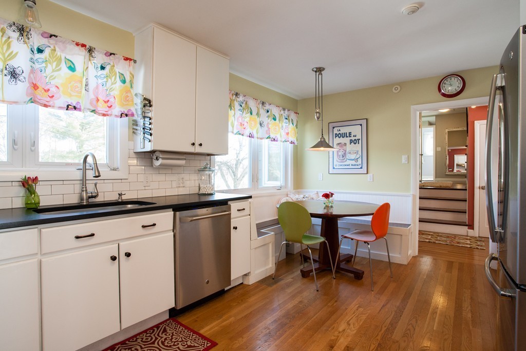 566 Newton Street Brookline, MA 02467 - Photo 11 of 30 a kitchen with stainless steel appliances wooden floor and dining table chairs