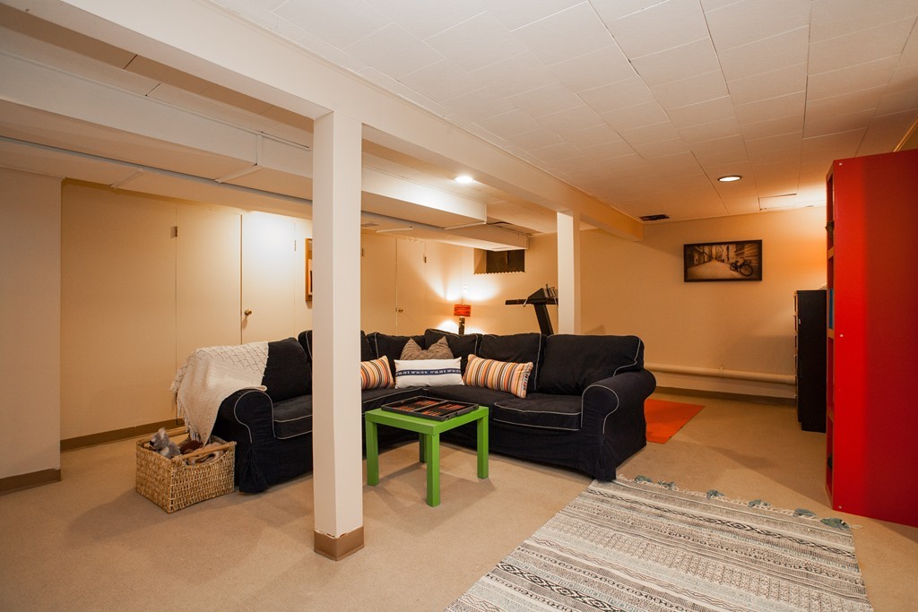 566 Newton Street Brookline, MA 02467 - Photo 27 of 30 a living room with furniture a lamp and a rug