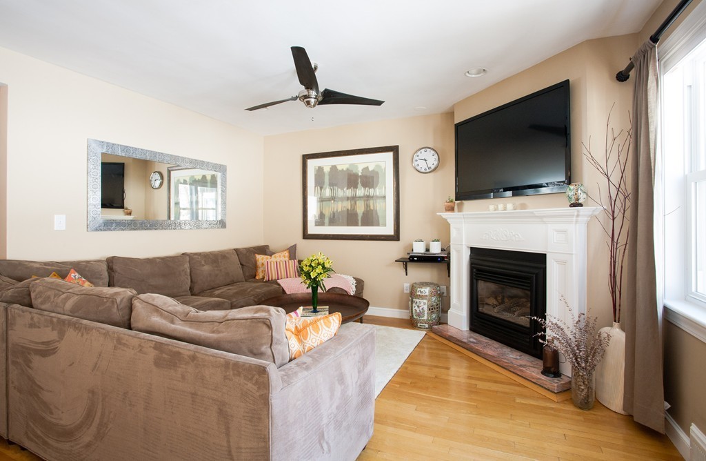 566 Newton Street Brookline, MA 02467 - Photo 3 of 30 a living room with furniture a flat screen tv and a fireplace