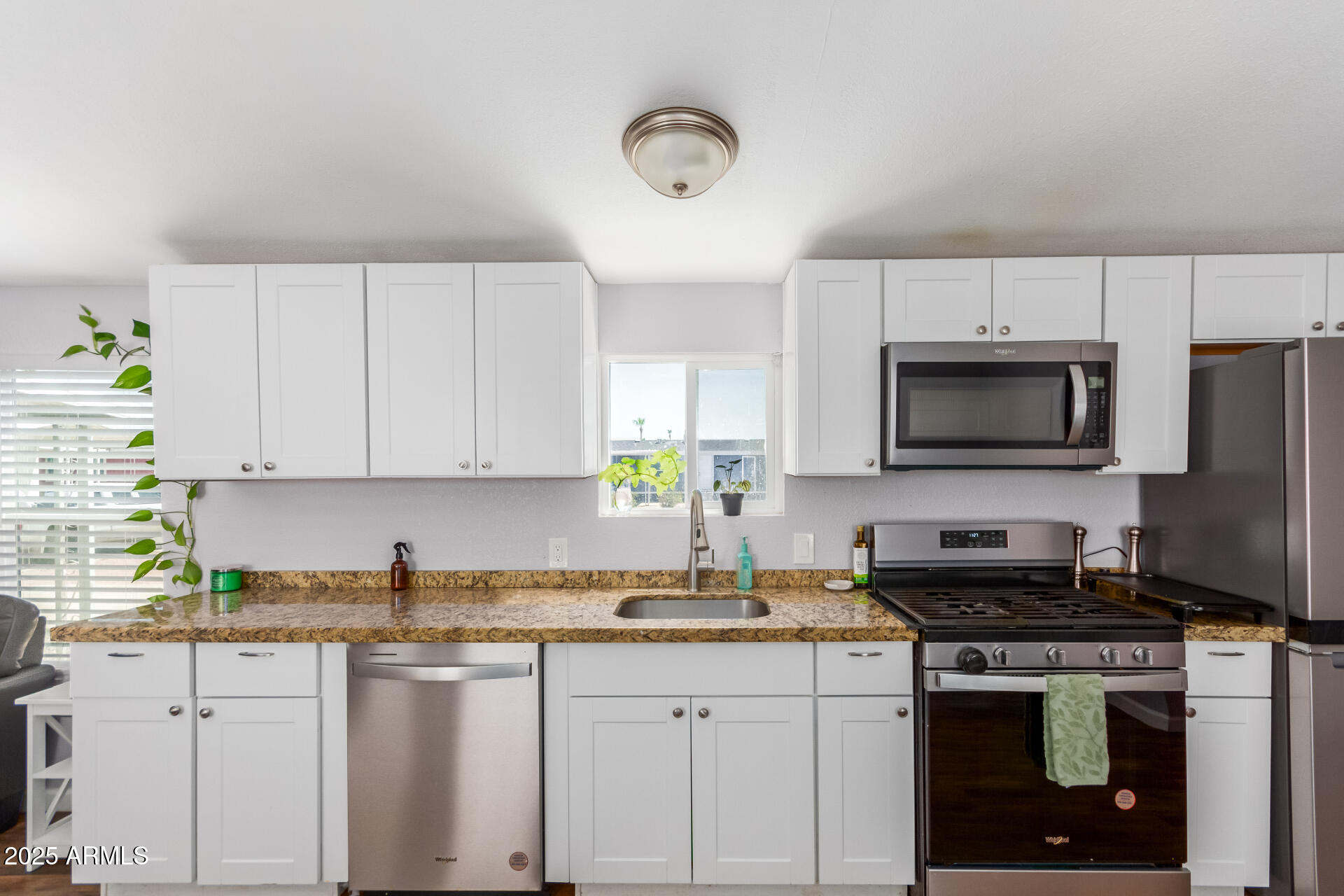 320 East McKellips Road, Unit 188 Mesa, AZ 85201 - Photo 13 of 28 a kitchen with stainless steel appliances granite countertop a sink a stove a microwave a refrigerator and cabinets