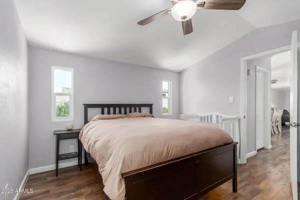 a bedroom with a large bed chandelier and a window