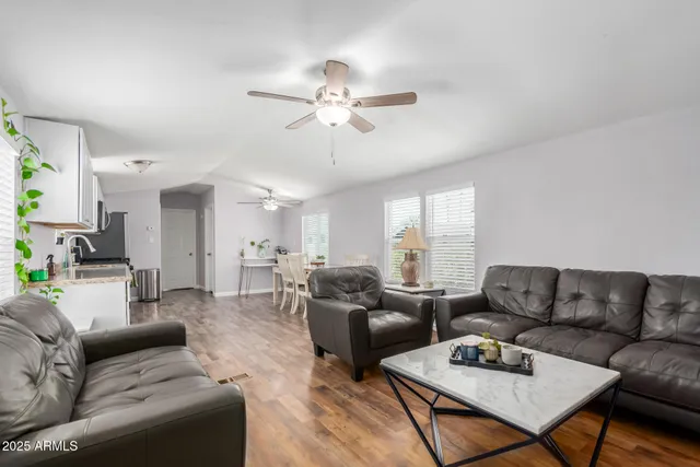 a living room with furniture a ceiling fan and a window