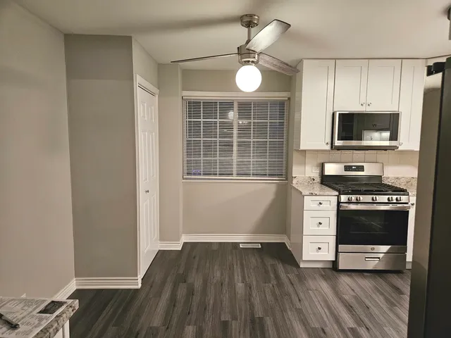 a kitchen with wooden floors and stainless steel appliances