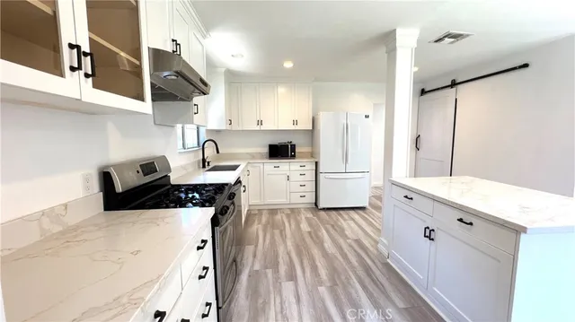 a kitchen with a sink a stove and cabinets