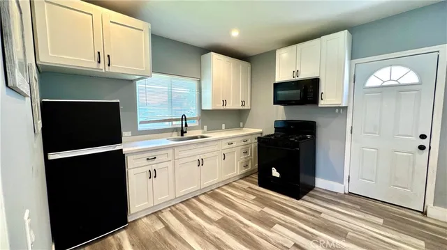 a kitchen with a refrigerator and a stove top oven