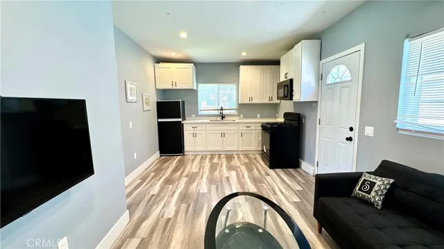 a large white kitchen with stainless steel appliances granite countertop a refrigerator and a stove top oven