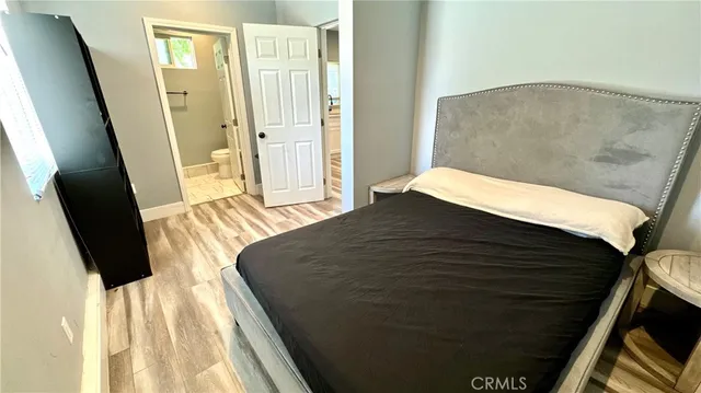 a bedroom with a bed and wooden floor