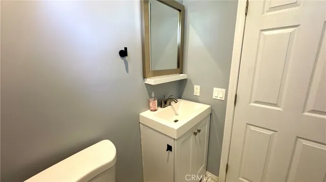 a bathroom with a sink a toilet and mirror