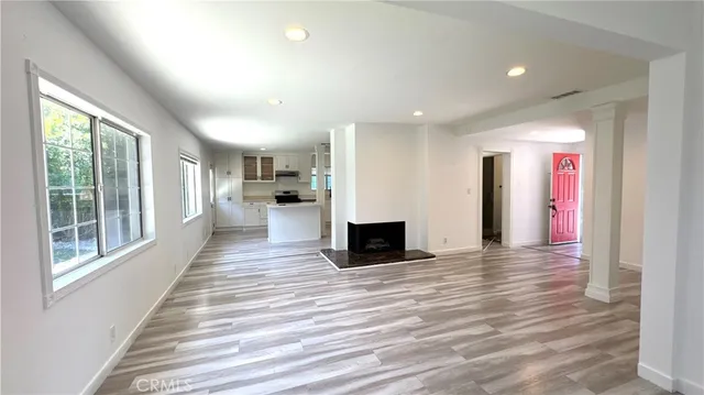 a view of a living room with windows and wooden floor