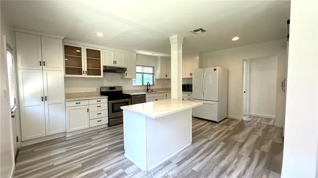 a kitchen with white cabinets and stainless steel appliances