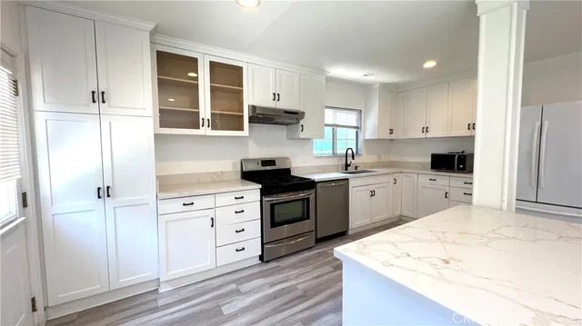 a kitchen with white cabinets and white appliances