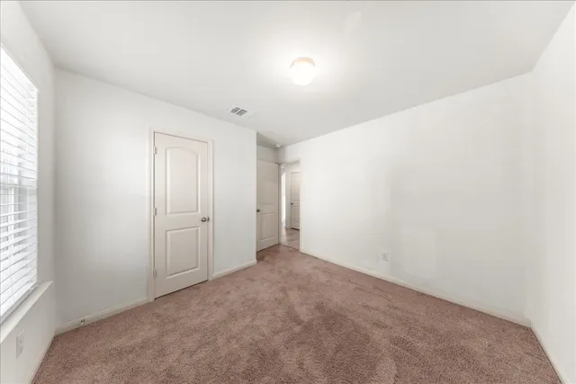 an empty room with windows and closet