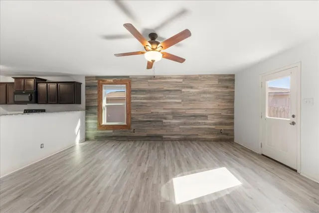 a view of a livingroom with wooden floor and a ceiling fan