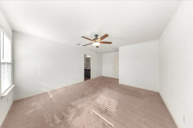 a view of a livingroom with a ceiling fan and window