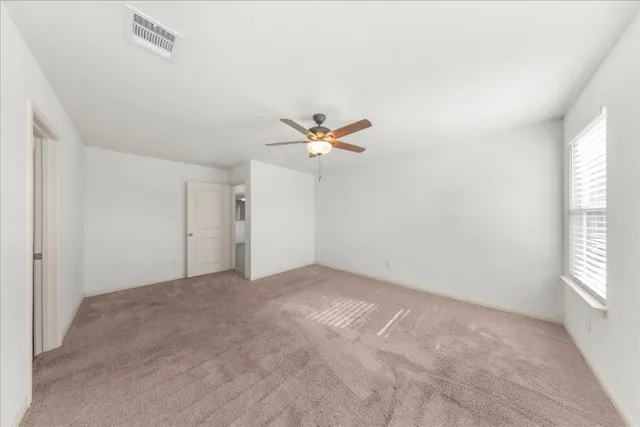 a view of a livingroom with a ceiling fan and window