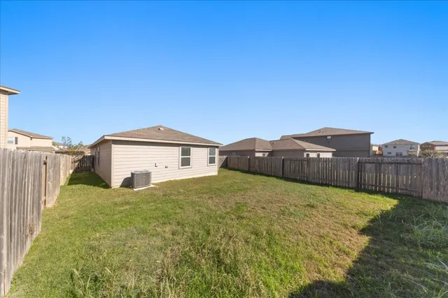 a view of a house with a yard and fence