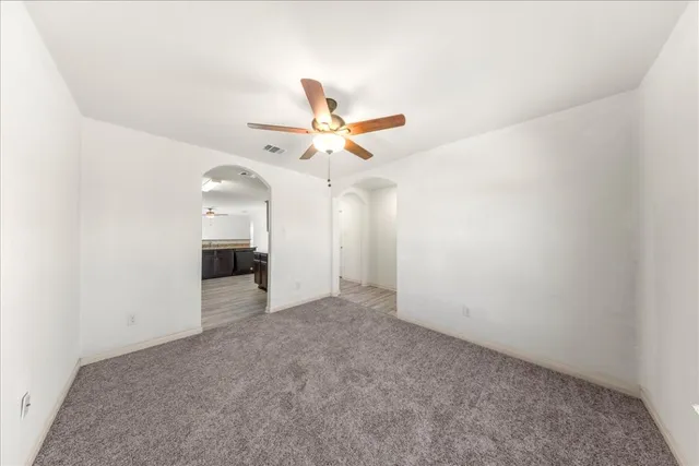 an empty room with a ceiling fan and a window