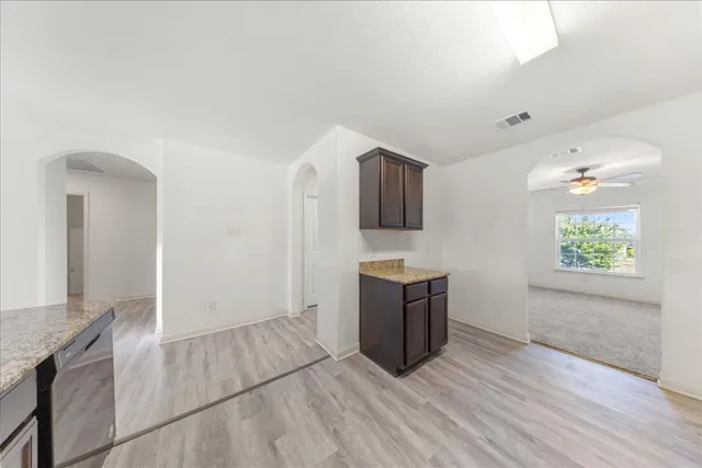 an empty room with kitchen appliances and wooden floor