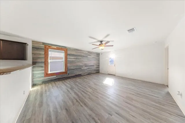 a view of a livingroom with wooden floor and a ceiling fan