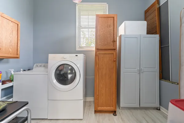 a bedroom with a bed a chandelier and dresser