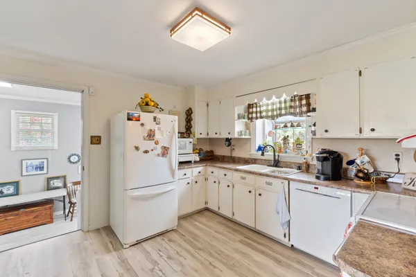 a kitchen with granite countertop a sink window and cabinets