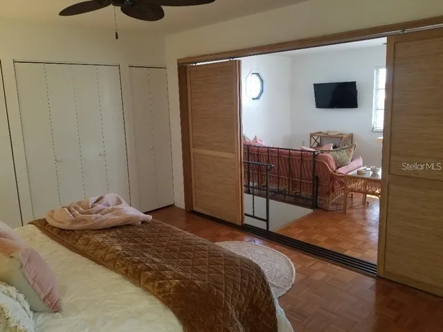 a bedroom with a bed and a flat tv screen on the dresser