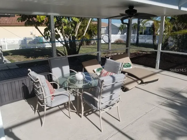 a view of a patio with a table chairs and a floor to ceiling window
