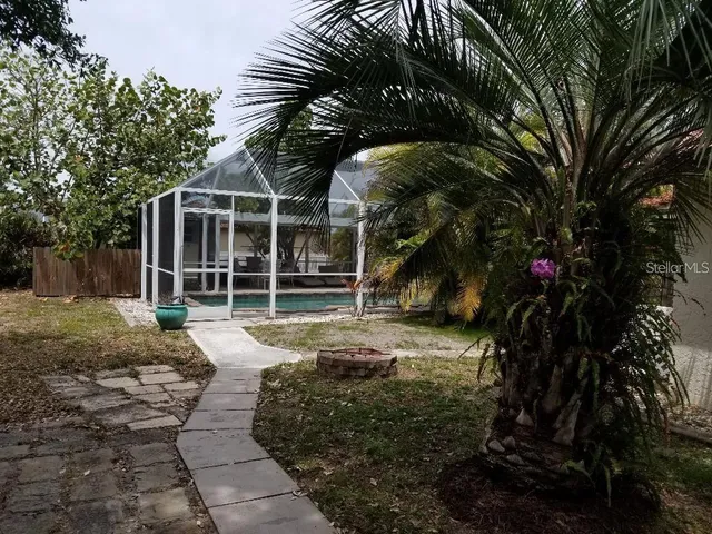 a view of a backyard with large trees and plants