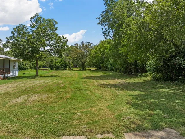 a view of a green field with wooden fence