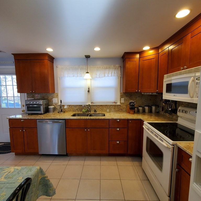 45 Nipigon Way West Dennis, MA 02639 - Photo 16 of 42 a large kitchen with stainless steel appliances granite countertop a stove a sink and a microwave