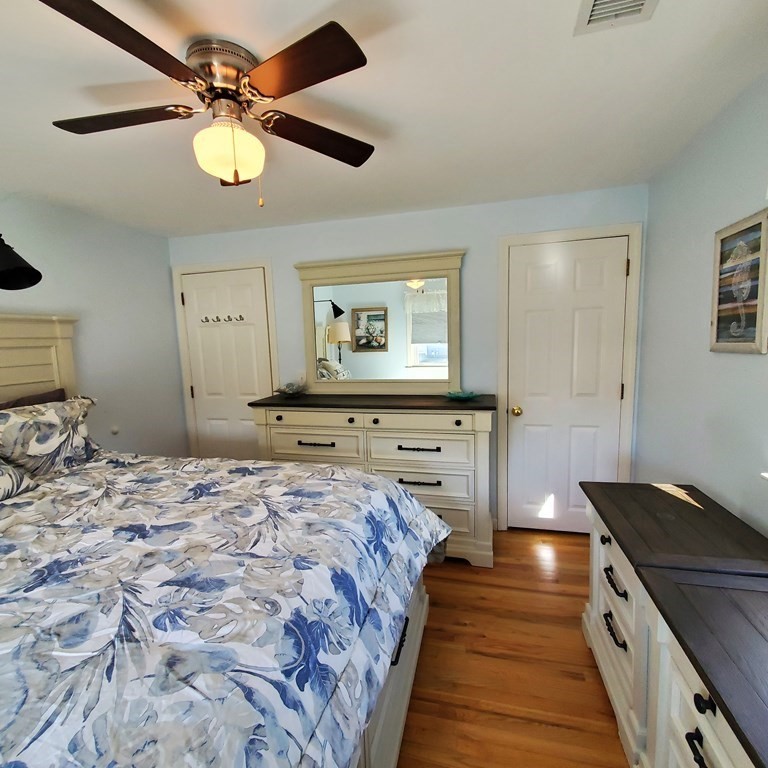 45 Nipigon Way West Dennis, MA 02639 - Photo 23 of 42 a spacious bedroom with a bed and a chandelier