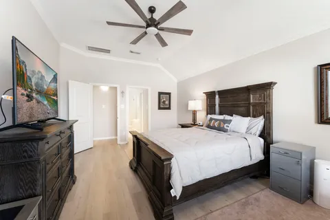 a spacious bedroom with a bed and a flat screen tv