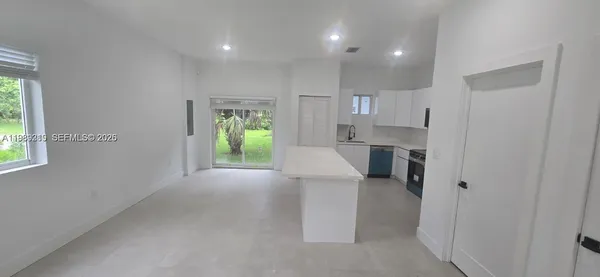 a open kitchen with white cabinets and stainless steel appliances