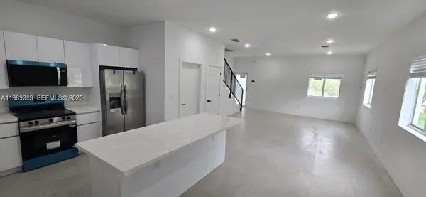 a kitchen with a refrigerator and a stove top oven