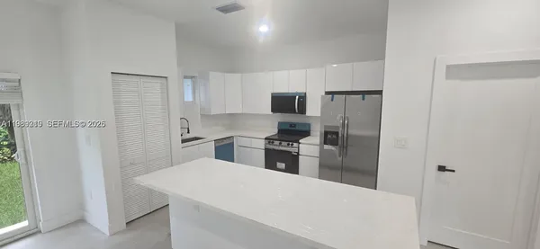 a kitchen with cabinets and stainless steel appliances