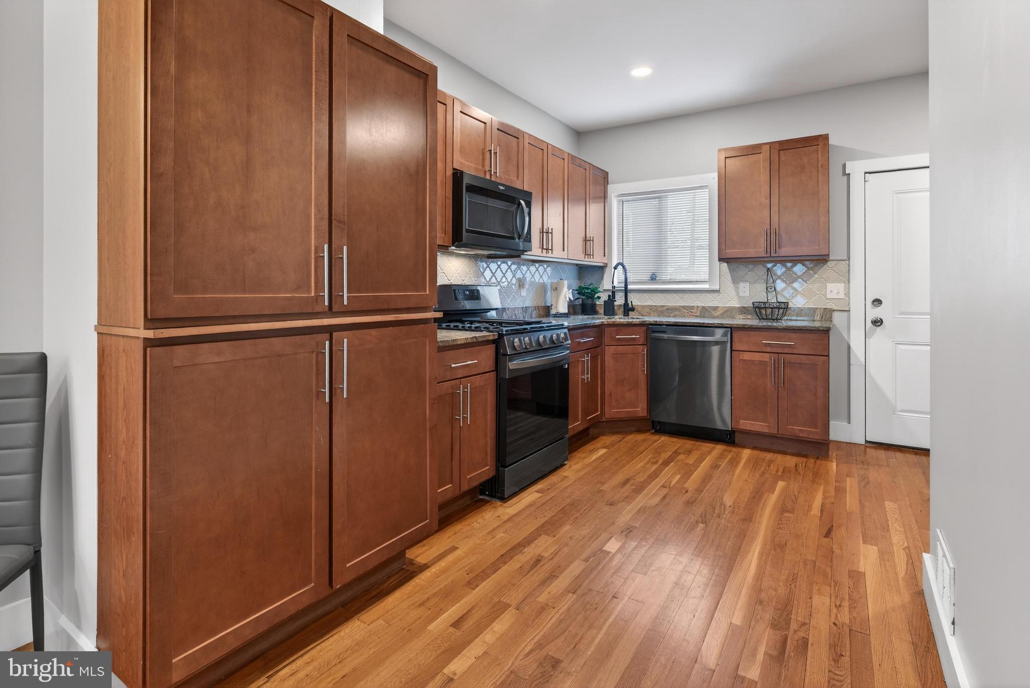 736 New Street Camden, NJ 08103 - Photo 6 of 20 a kitchen with stainless steel appliances granite countertop a refrigerator a stove top oven a sink and dishwasher with wooden floor