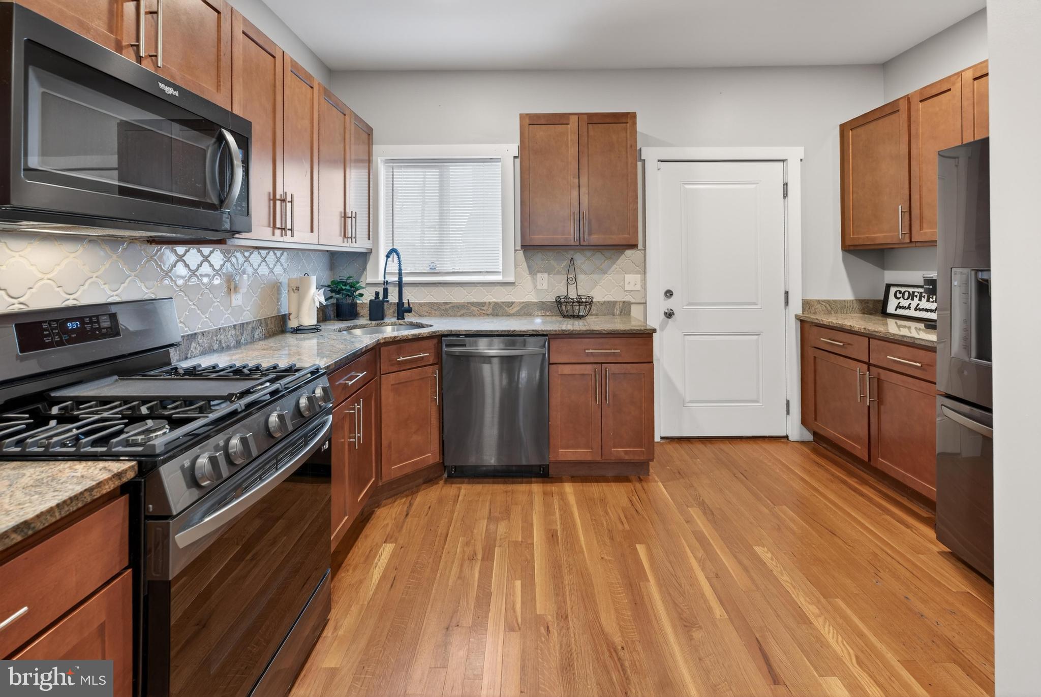 736 New Street Camden, NJ 08103 - Photo 7 of 20 a kitchen with stainless steel appliances granite countertop wooden cabinets a stove top oven a sink and dishwasher