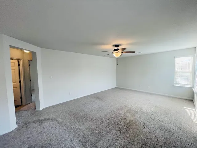 a view of a livingroom with a ceiling fan and window