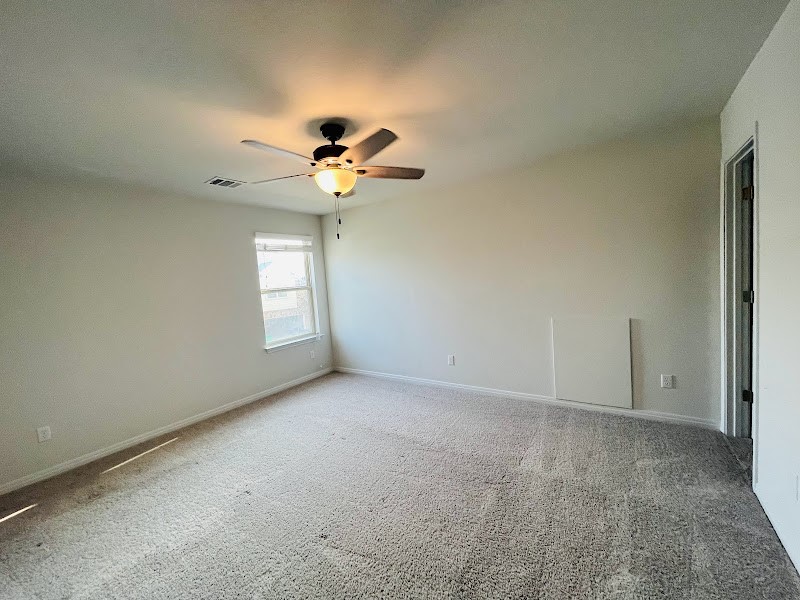 4012 Birdwatch Loop, Unit 8 Pflugerville, TX 78660 - Photo 22 of 23 an empty room with windows and chandelier fan