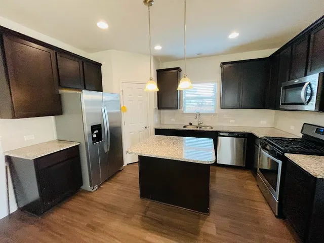 a kitchen with stainless steel appliances a refrigerator a stove a sink and a microwave