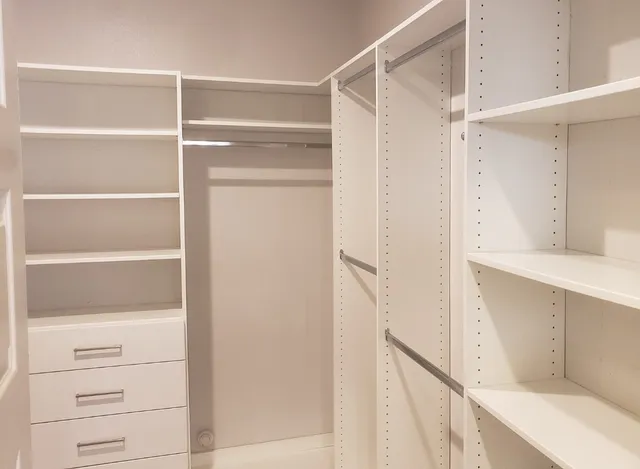 a view of a hallway with wooden shelves
