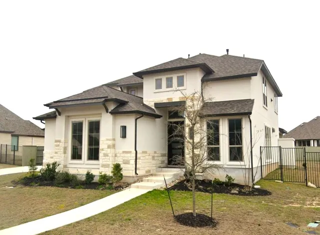 a view of a white house with large windows and a table