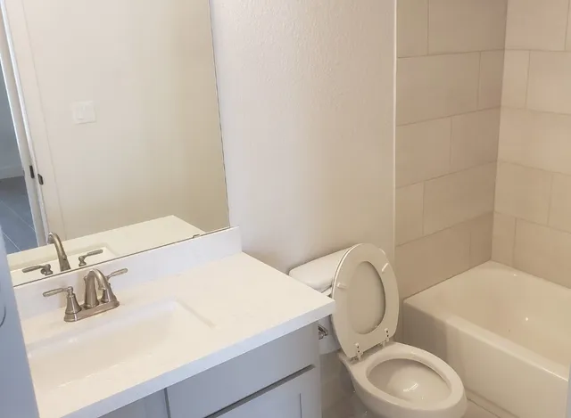 a bathroom with a sink toilet and a mirror