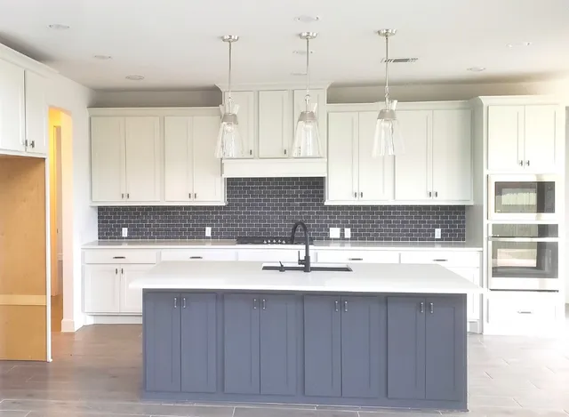 a kitchen with a sink refrigerator and cabinets