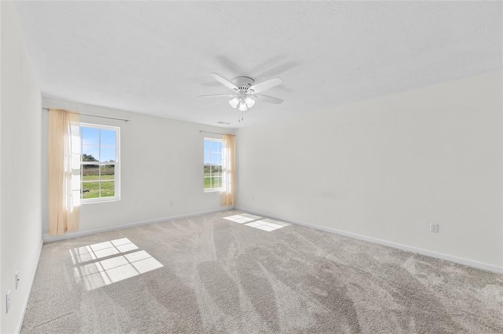 1024 Colonial Drive Uniontown, PA 15401 - Photo 14 of 33 an empty room with windows and ceiling fan view