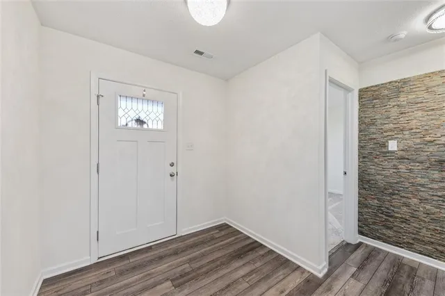 a view of empty room with wooden floor