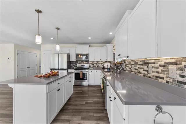 a kitchen with stainless steel appliances kitchen island granite countertop a sink and cabinets