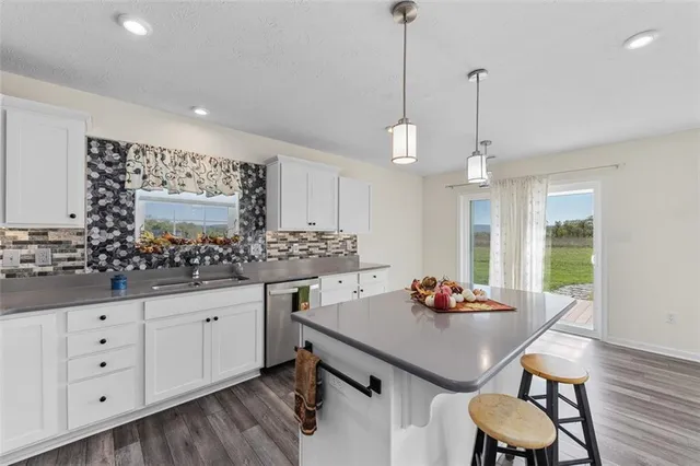 a kitchen with granite countertop white cabinets and chairs